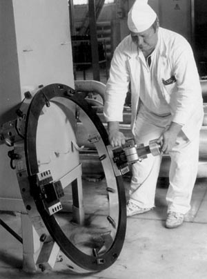 Picture of technician demonstrating pipe lathe/weld-preparation equipment.